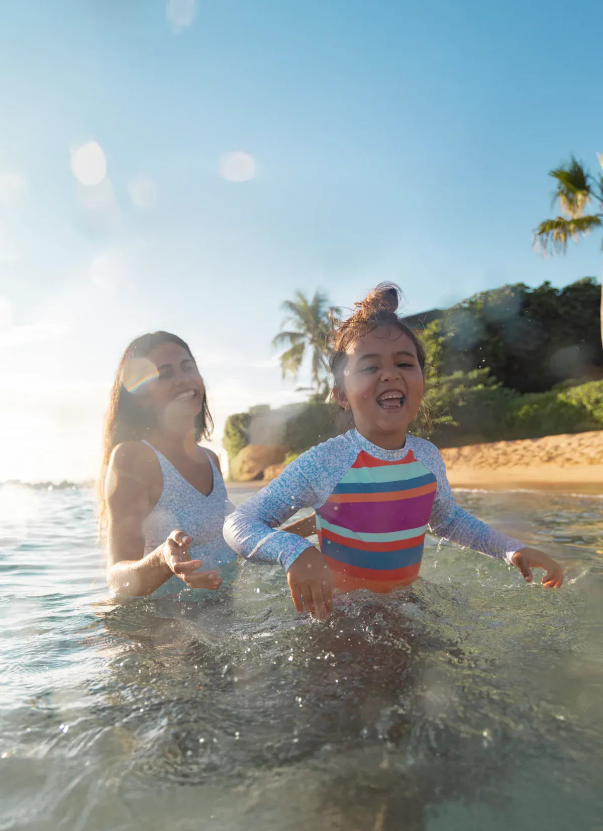 a group of young girls on the beach wearing nani swimsuits