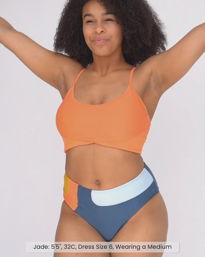 Video of a girl showing the fit of the textured orange swimsuit top