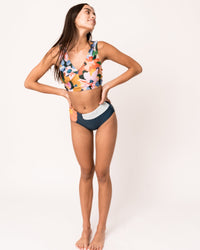 Studio photo of a happy women wearing a colorful patterned swimsuit. 