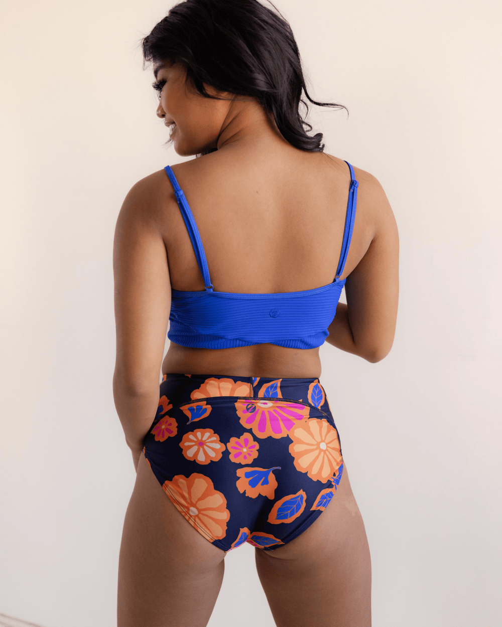Back View studio picture showing the bold orange and pink floral swimsuit bottom