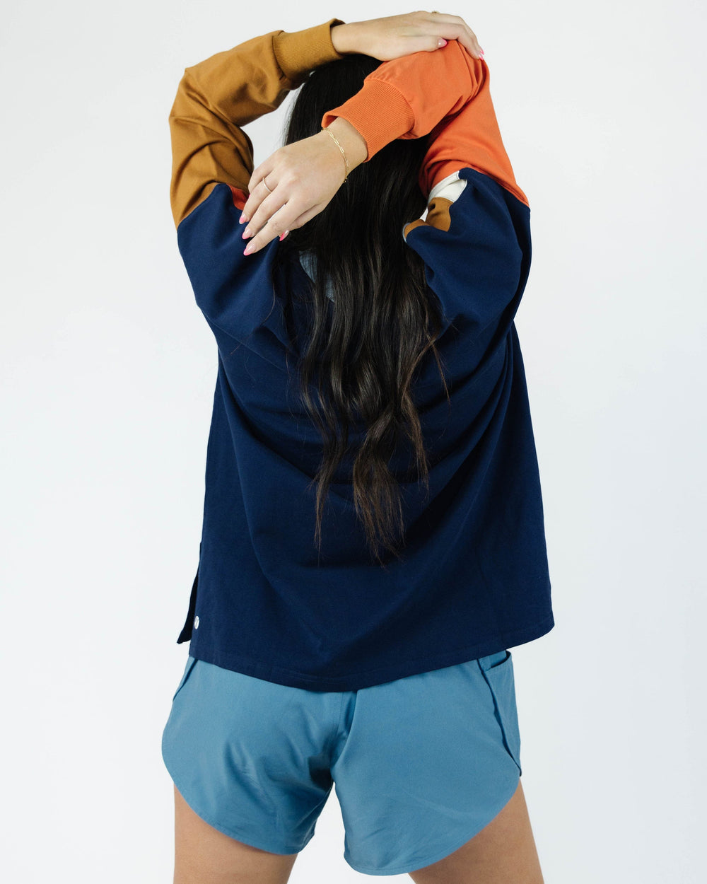 A women modeling a blue, orange, yellow and white color blocked crewneck.