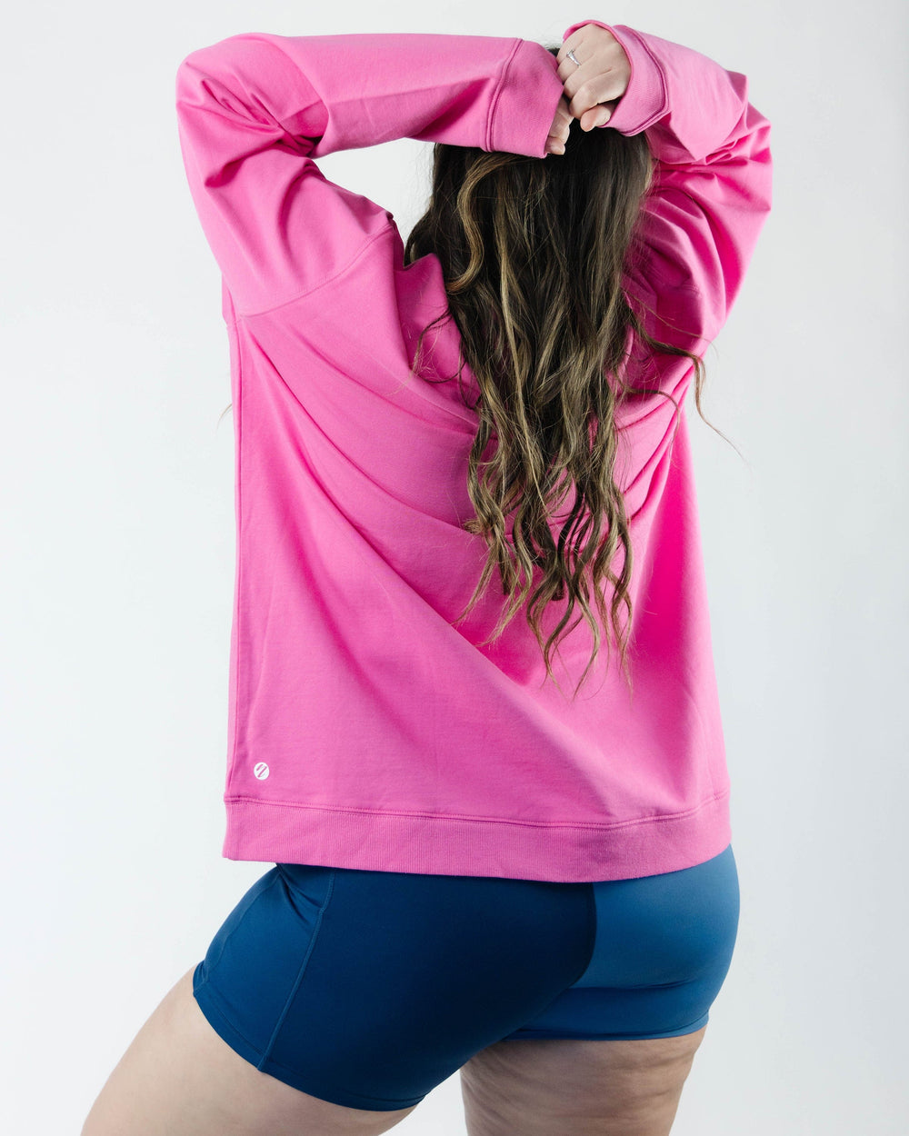 A women wearing a hot pink long sleeve  crewneck sweatshirt.