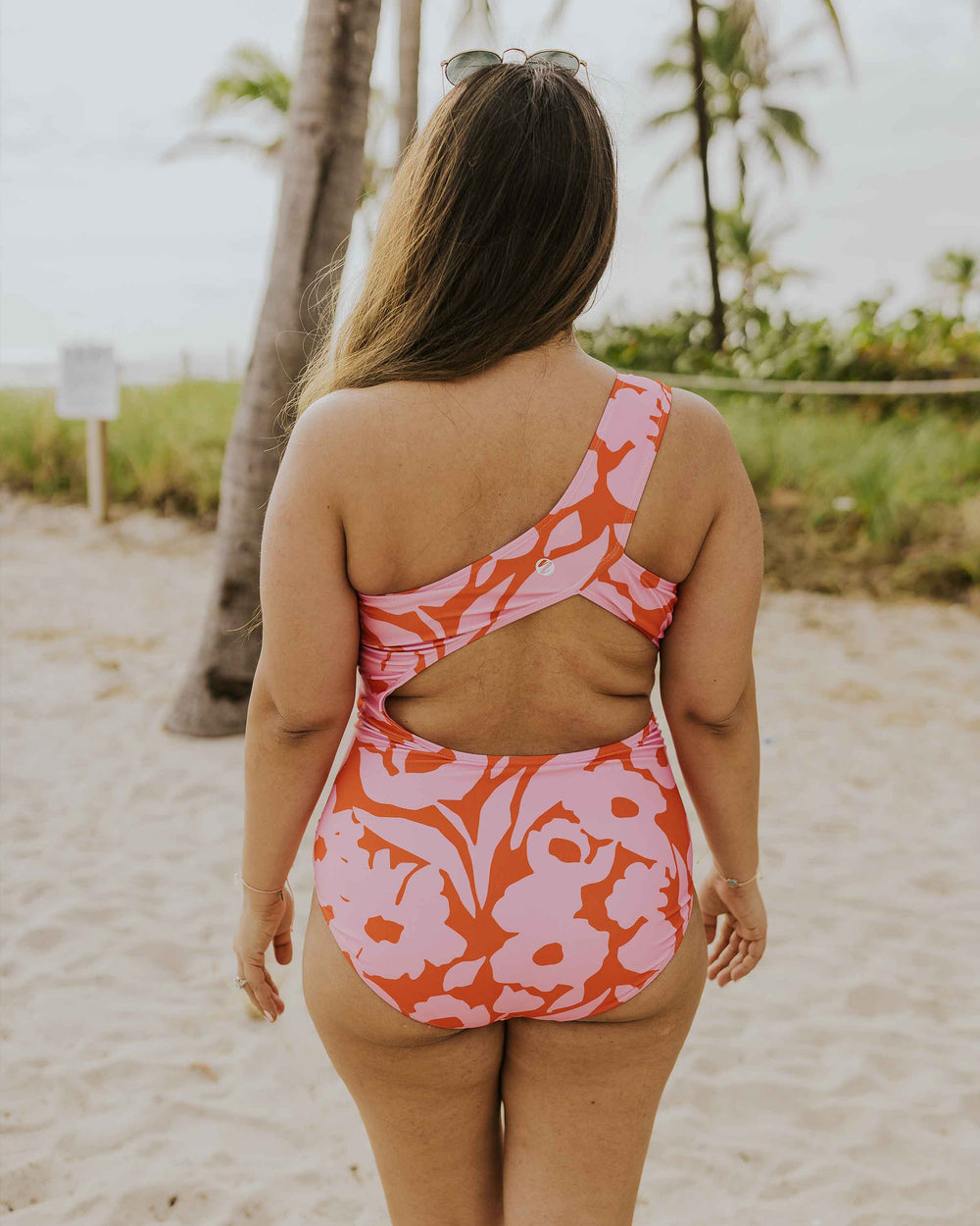 The back side of a pink and red floral swimsuit.