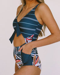 Close up studio image of a navy one piece  with a keyhole cut out in the front.