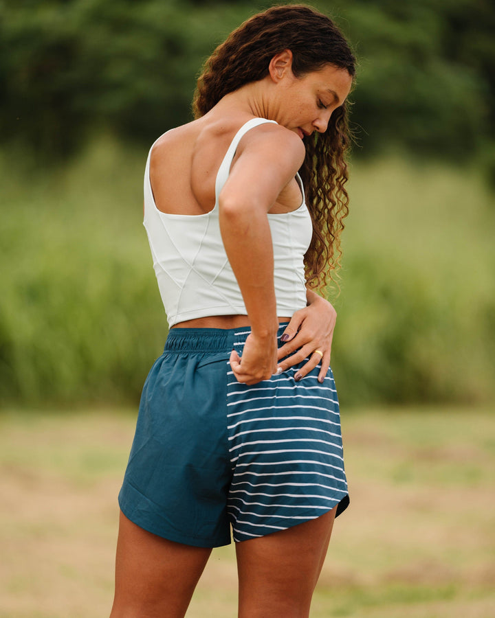 A women working out in a  blue and white striped skort.
