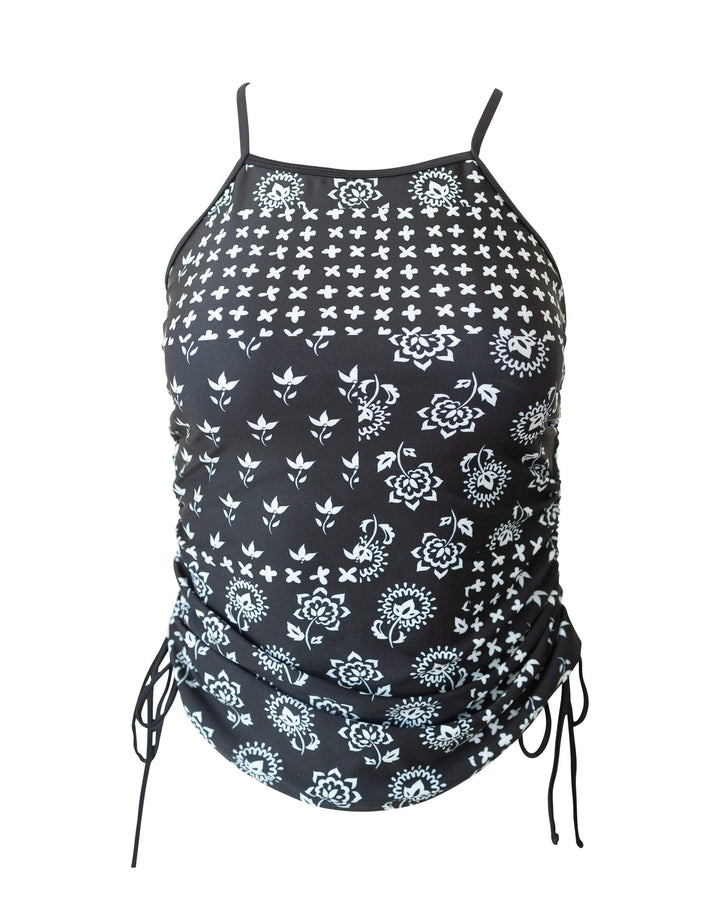 Flat lay image of a black and white floral tankini with ties on the side.