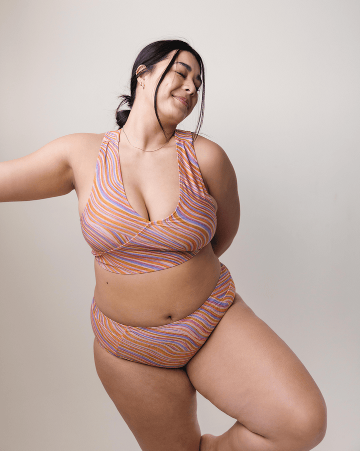 Front View studio picture of a girl wearing a retro pink, blue, purple and orange wave bikini set