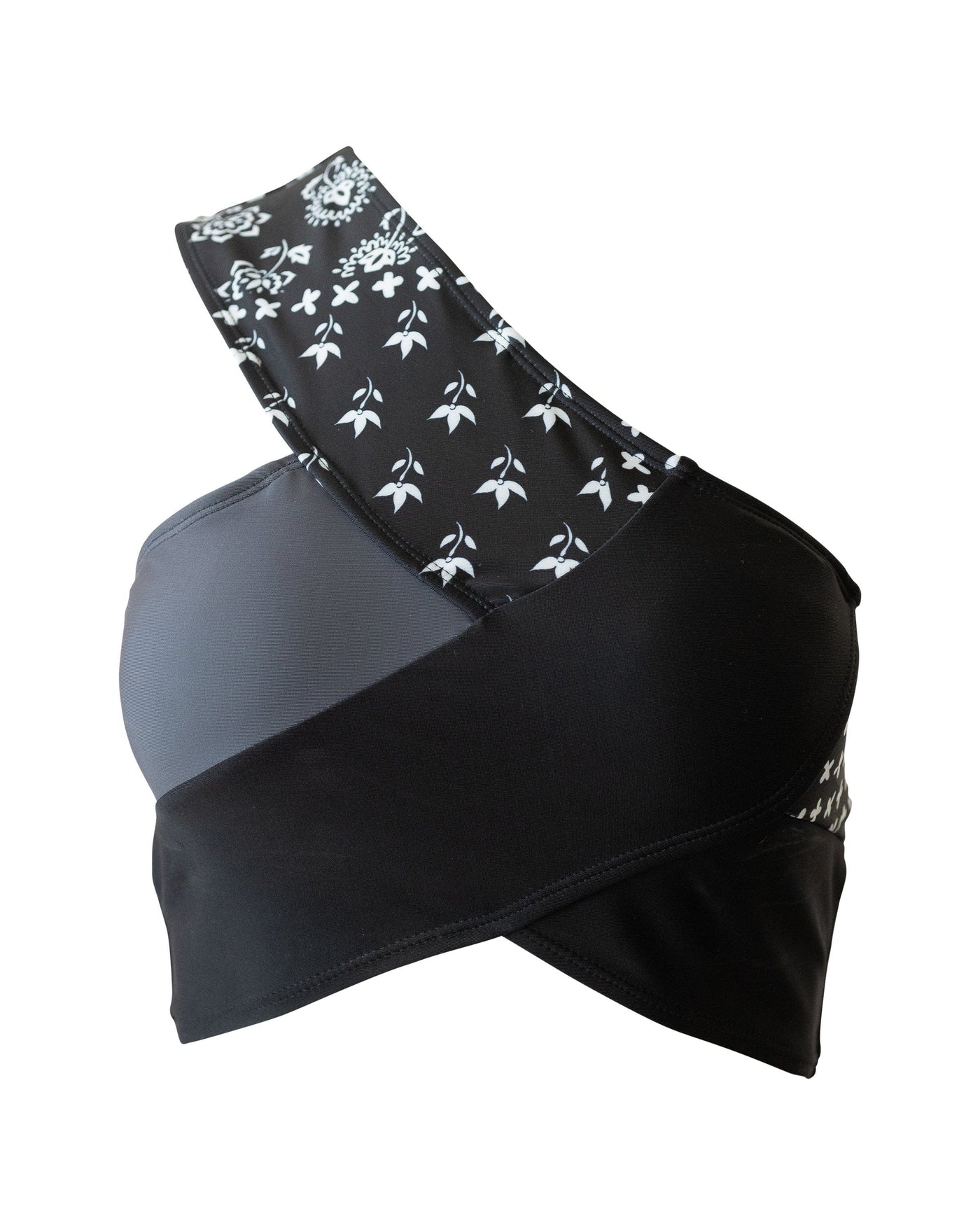 Flat lay of a black, white, and gray patchwork swimsuit top.