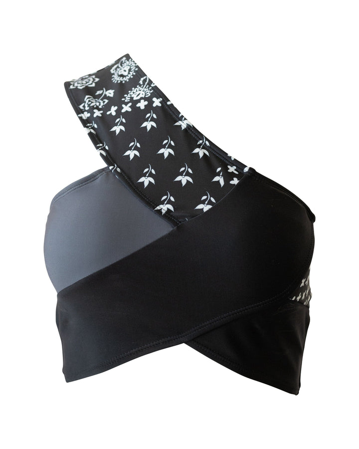 Flat lay of a black, white, and gray patchwork swimsuit top.