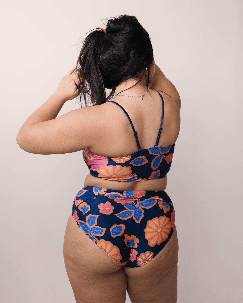 Back view studio image of bold floral patterned swimsuit bottoms.