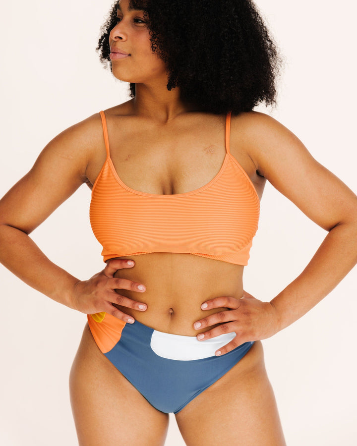 Front view Studio picture of a girl wearing textured orange bikini top